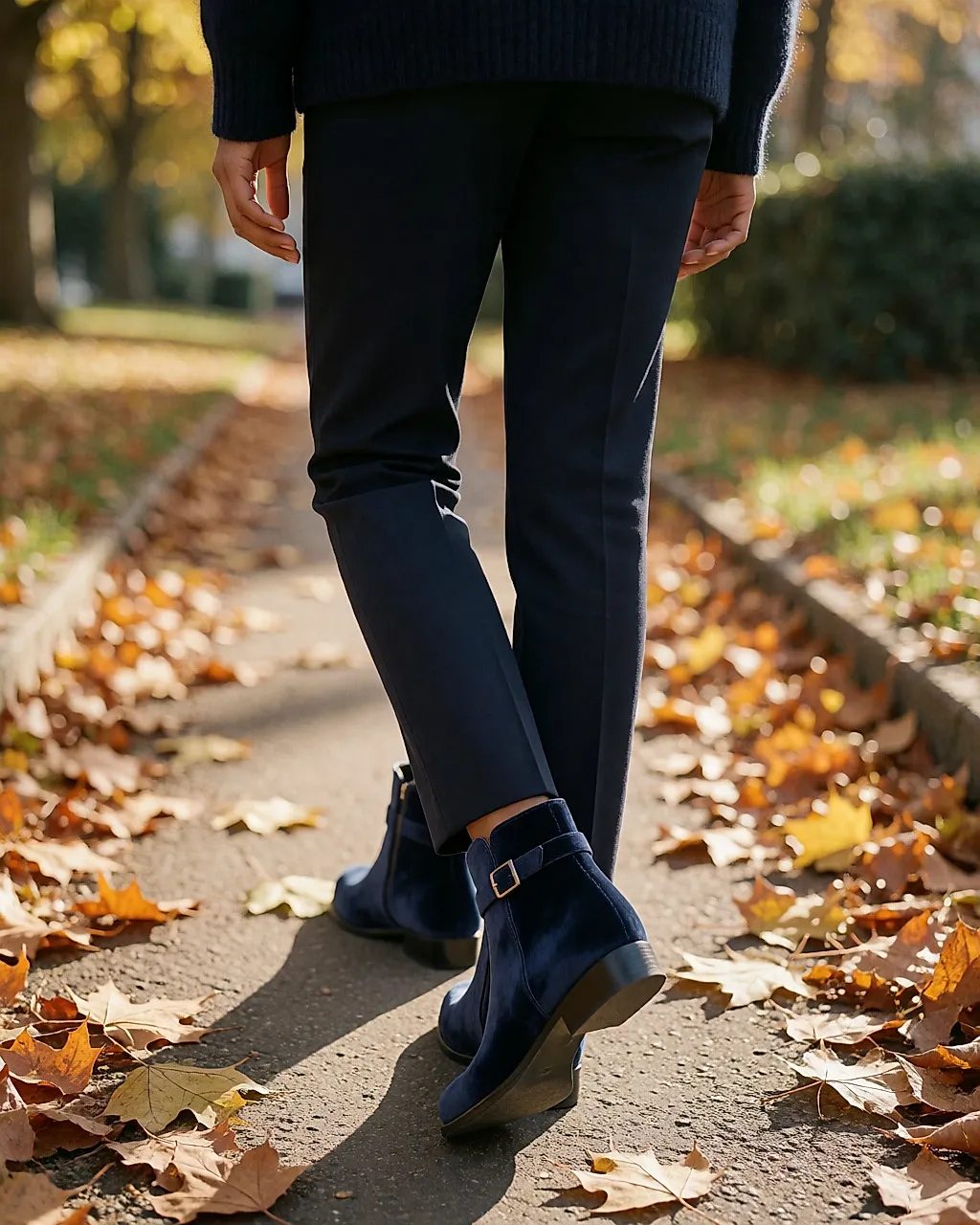 Femme de dos marchant, boots en cuir velours bleu marine sanglées
